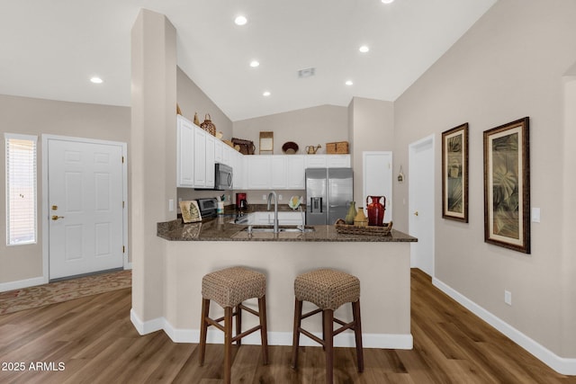 4332 E Cassia Ln, Gilbert, AZ 85298 - kitchen featuring appliances with stainless steel finishes, a sink, a peninsula, dark wood-type flooring, and lofted ceiling