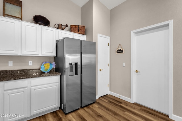 4332 E Cassia Ln, Gilbert, AZ 85298 - kitchen with stainless steel fridge with ice dispenser, wood finished floors, white cabinets, baseboards, and dark stone countertops