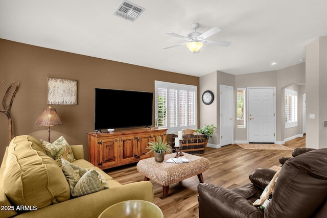 4332 E Cassia Ln, Gilbert, AZ 85298 - living room with arched walkways, ceiling fan, light wood-type flooring, and plenty of natural light