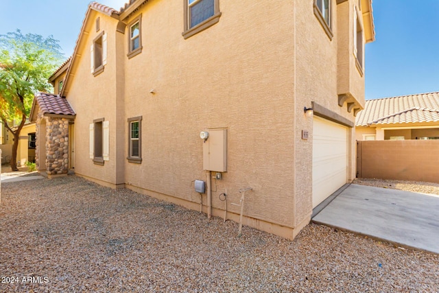 935 E Agua Fria Ln, Avondale, AZ 85323 - view of home's exterior featuring stucco siding, a tile roof, concrete driveway, and a garage