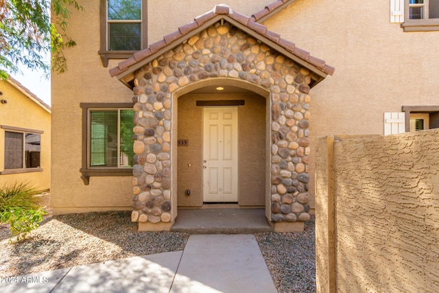 935 E Agua Fria Ln, Avondale, AZ 85323 - doorway to property with stucco siding, stone siding, and a tiled roof