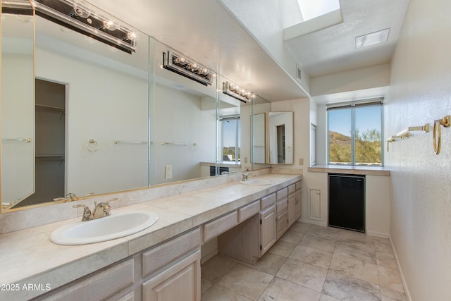 bathroom with tile patterned floors, vanity, and a textured ceiling