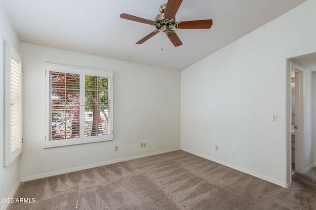 carpeted spare room featuring vaulted ceiling and ceiling fan