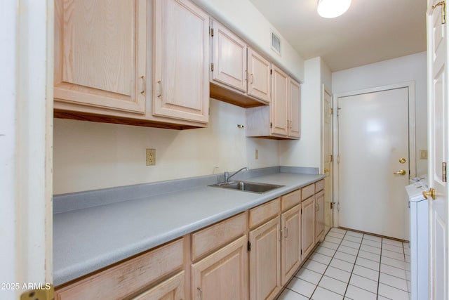 kitchen featuring light brown cabinetry, sink, and light tile patterned floors