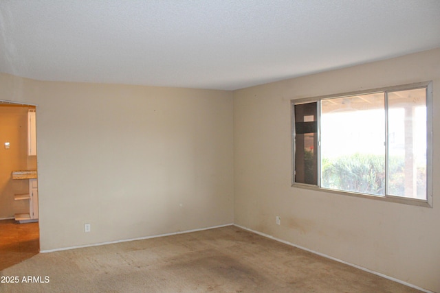 empty room with baseboards and carpet