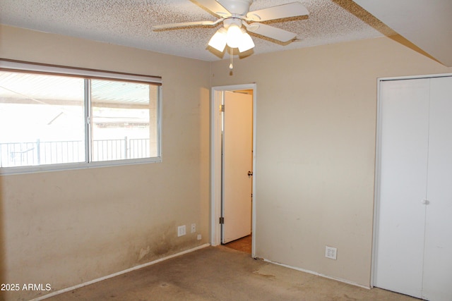 unfurnished bedroom with a closet, ceiling fan, a textured ceiling, and carpet floors