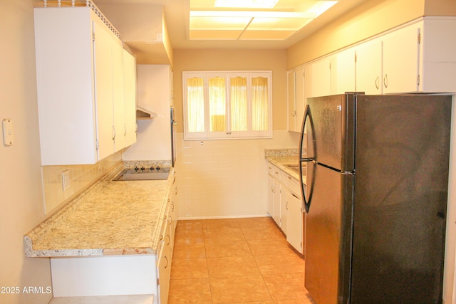 kitchen featuring light tile patterned floors, light countertops, white cabinetry, tile walls, and black appliances