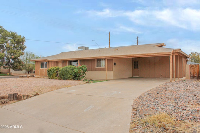ranch-style house featuring driveway, fence, and an attached carport