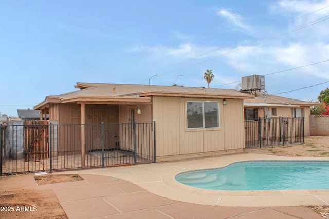 rear view of house featuring cooling unit, a patio, a fenced in pool, and fence