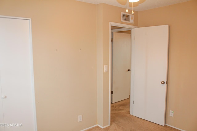 unfurnished bedroom with visible vents, light colored carpet, and a textured ceiling