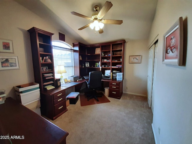 office area with baseboards, vaulted ceiling, light colored carpet, and ceiling fan