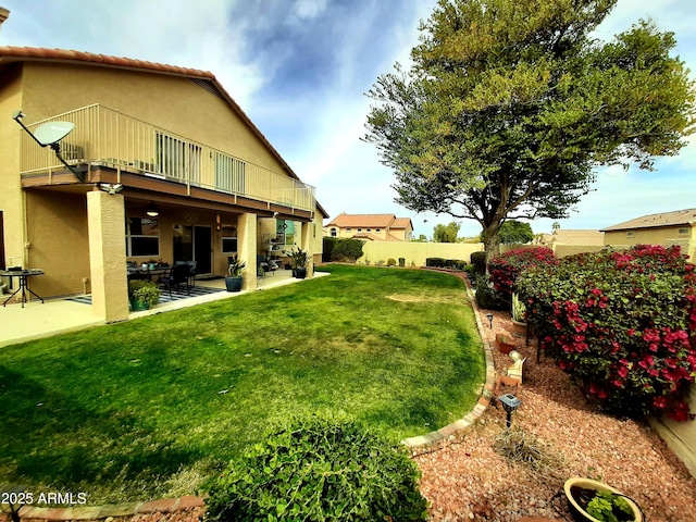 view of yard with a patio, a balcony, and fence