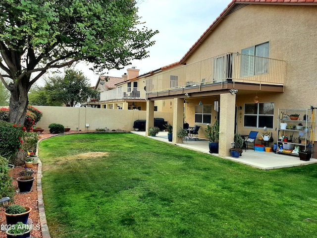 view of yard featuring fence, a patio area, and a balcony