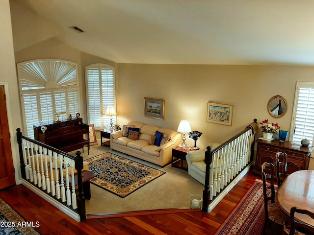 living area with vaulted ceiling, wood finished floors, and visible vents