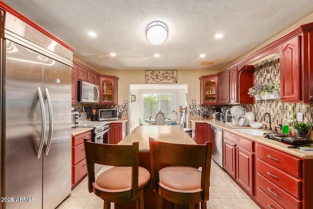 3121 W Greenway Rd, Phoenix, AZ 85053 - kitchen with a sink, light countertops, appliances with stainless steel finishes, dark brown cabinets, and decorative backsplash