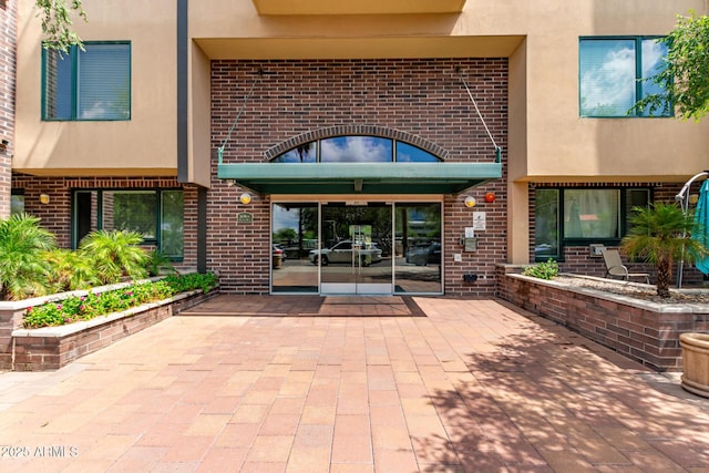 16 W Encanto Blvd Unit 26, Phoenix, AZ 85003 - doorway to property featuring brick siding, a patio, and stucco siding