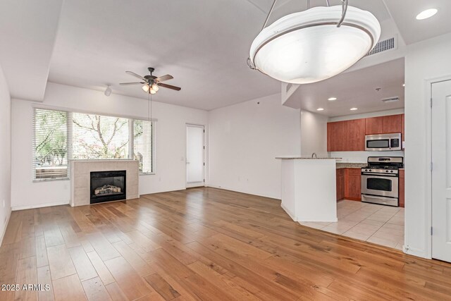 16 W Encanto Blvd Unit 26, Phoenix, AZ 85003 - unfurnished living room with ceiling fan, light wood finished floors, a tiled fireplace, and recessed lighting