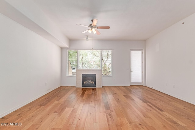 16 W Encanto Blvd Unit 26, Phoenix, AZ 85003 - unfurnished living room featuring light wood-style flooring, ceiling fan, a fireplace, and baseboards