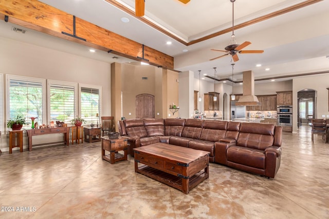 living room featuring crown molding, ceiling fan, and a raised ceiling