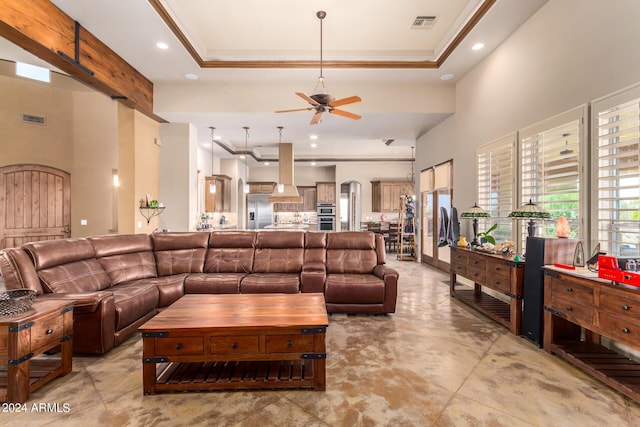 living room featuring ornamental molding, a raised ceiling, and ceiling fan