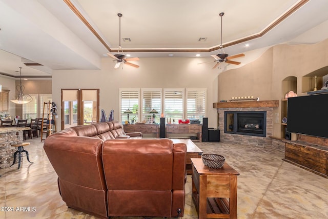 living room featuring ceiling fan, ornamental molding, and a tray ceiling