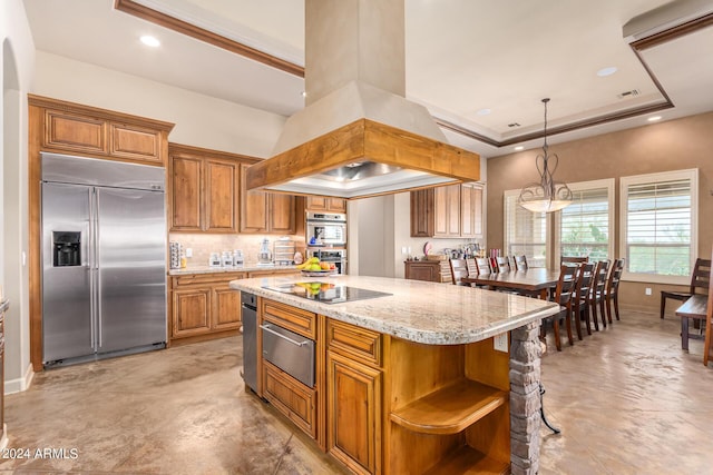 kitchen featuring island range hood, a center island, appliances with stainless steel finishes, a tray ceiling, and pendant lighting