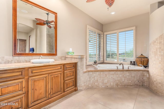 bathroom featuring vanity, a relaxing tiled tub, and ceiling fan