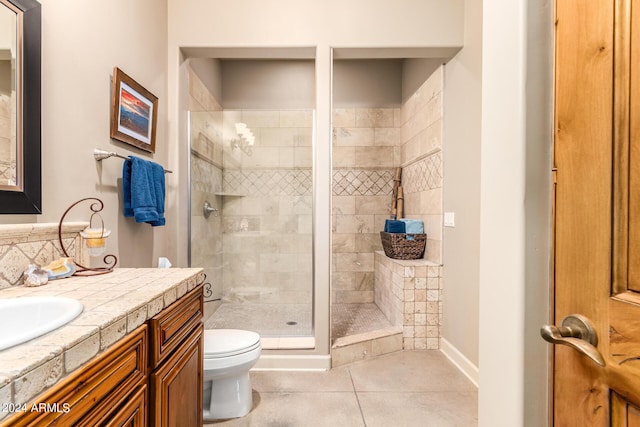 bathroom featuring tile patterned flooring, vanity, an enclosed shower, and toilet