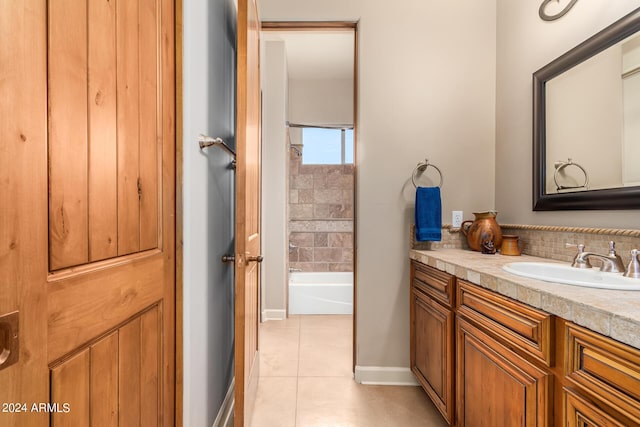 bathroom with a tub to relax in, tile patterned floors, and vanity