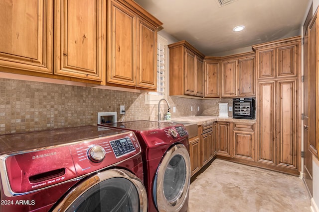 laundry area with separate washer and dryer, sink, and cabinets