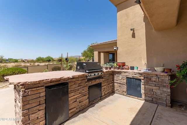 view of patio / terrace featuring area for grilling, sink, and an outdoor kitchen