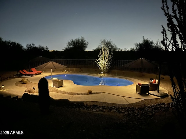 pool at dusk with a patio