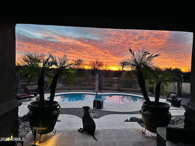 pool at dusk with a patio