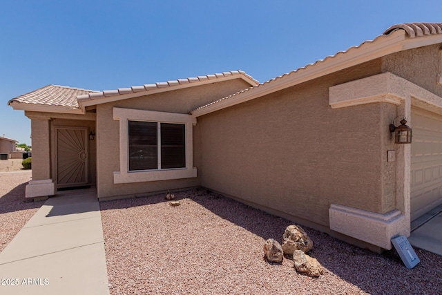 1341 E Bellerive Dr, Chandler, AZ 85249 - view of exterior entry featuring a tiled roof and stucco siding