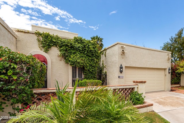 view of front of property with stucco siding, driveway, and an attached garage