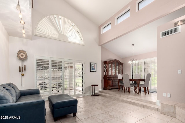 tiled living room with high vaulted ceiling, a chandelier, healthy amount of natural light, and baseboards