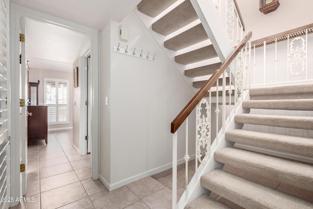 stairs with tile patterned flooring and baseboards