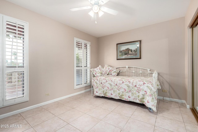 bedroom with light tile patterned floors, baseboards, ceiling fan, and a closet