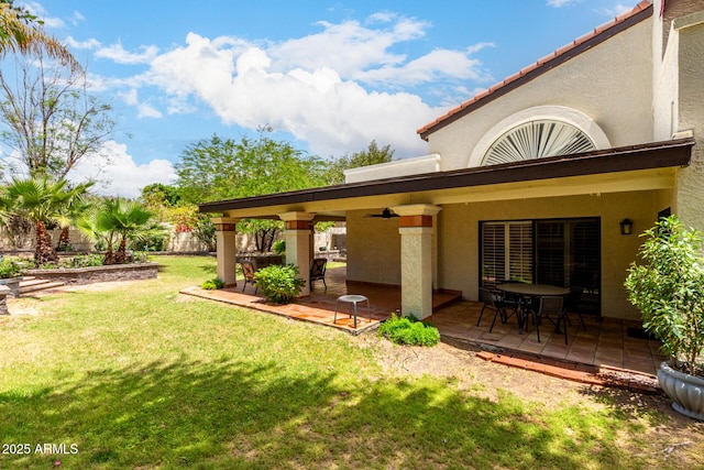 view of green lawn featuring a ceiling fan and a patio area