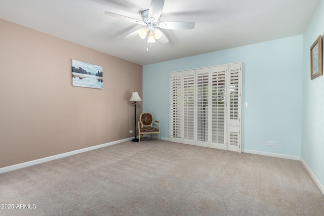 spare room with ceiling fan, carpet floors, and baseboards