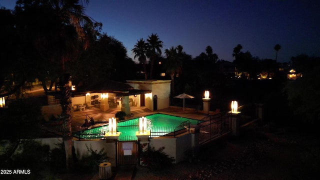pool at twilight featuring a patio area
