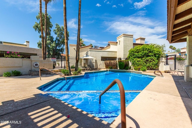 community pool with fence and a patio
