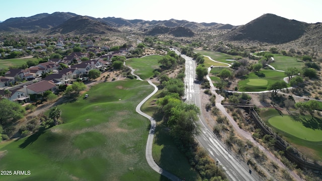 aerial overview of property's location with nearby suburban area, a golf club, and a mountainous background
