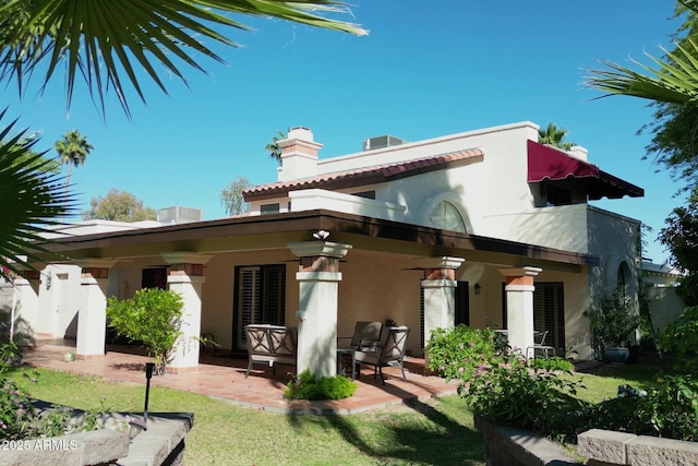 back of house featuring a patio, stucco siding, and a chimney