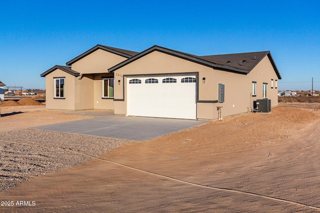 view of front of house featuring a garage, central AC, and electric panel