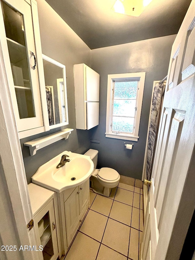 bathroom featuring vanity, curtained shower, tile patterned flooring, and toilet