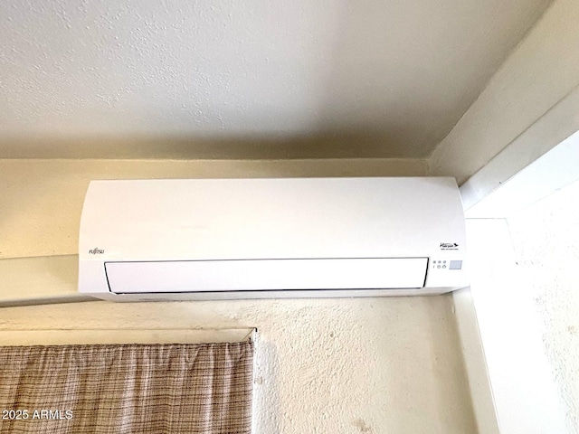 room details featuring a textured ceiling and an AC wall unit