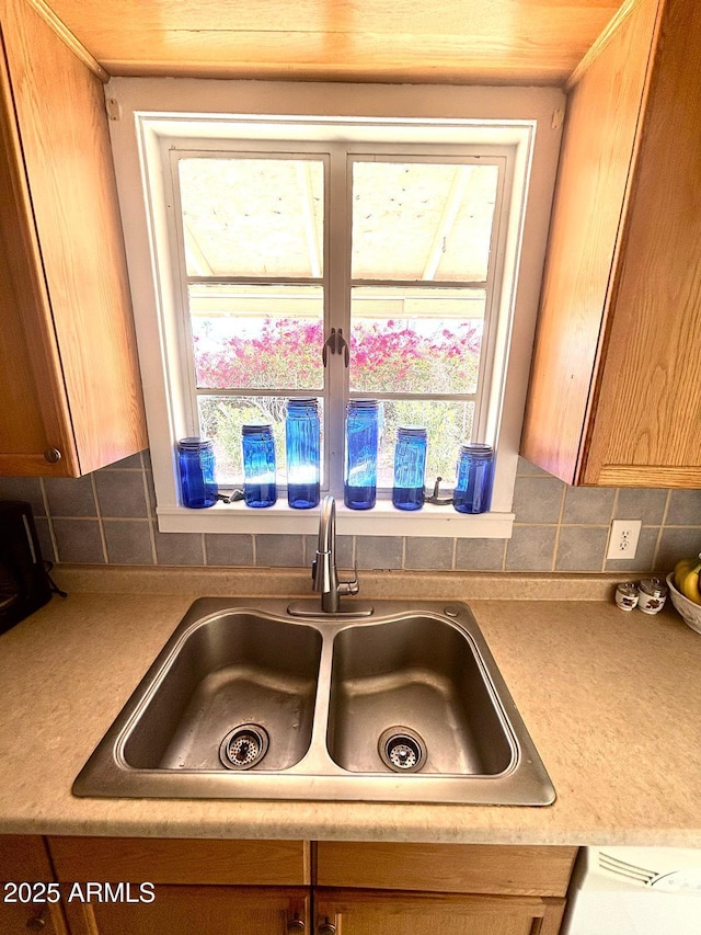 room details featuring light countertops, a sink, and decorative backsplash