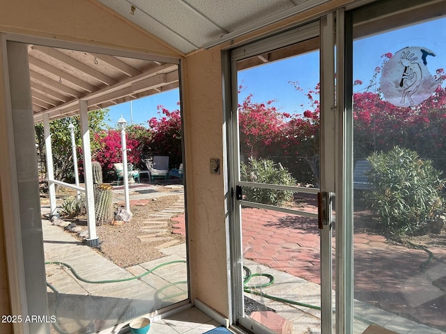 doorway to outside with vaulted ceiling