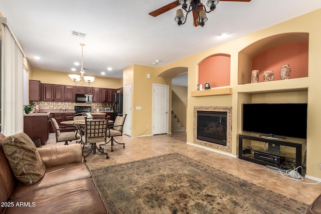 2526 W Florentine Rd, Phoenix, AZ 85086 - living area featuring a chandelier, ceiling fan, a glass covered fireplace, baseboards, and recessed lighting